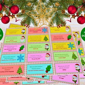 Può includere: Un mucchio di biglietti colorati con barzellette natalizie con illustrazioni di Babbo Natale, fiocchi di neve e alberi di Natale. Le carte hanno varie barzellette stampate. L'immagine include anche il testo "100 DIFFERENT JOKES" e "INSTANT DOWNLOAD".