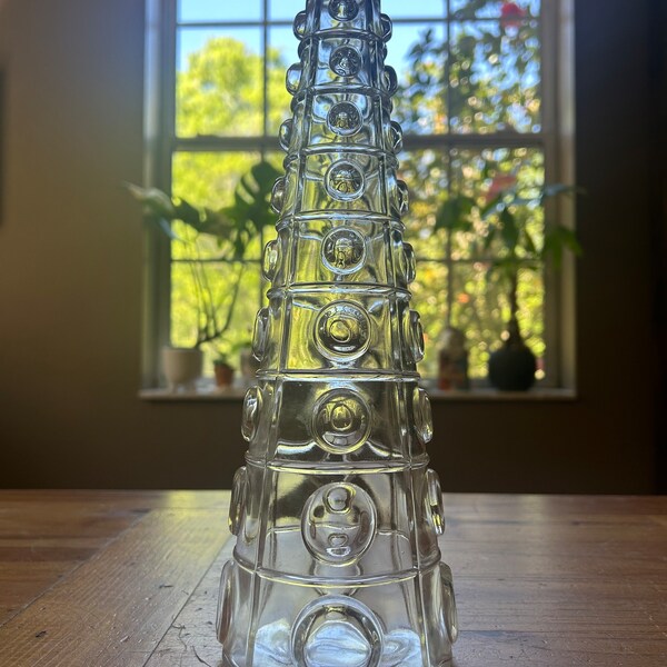 Tall clear glass vase with rows of embossed circles surrounding the entirety of the piece