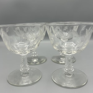 May include: Set of four clear glass stemmed dessert dishes with a delicate etched floral design.