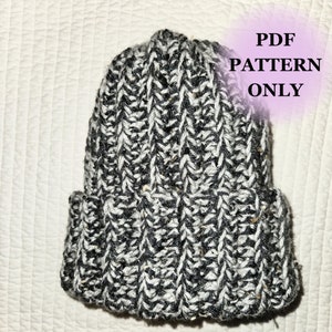 May include: A black and white crocheted beanie hat. The hat has a ribbed texture and a fold-over brim. The text "PDF PATTERN ONLY" is written in pink on a white background in the upper right corner of the image.