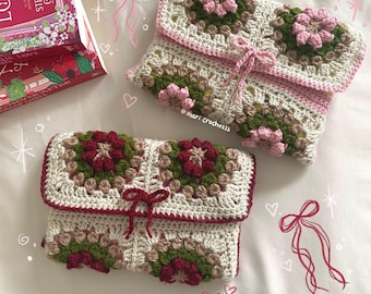 May include: Two crocheted pouches with a granny square design. One pouch is pink and green with a pink bow. The other pouch is red and green with a red bow. Both pouches have a white background.
