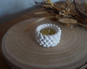 Peut inclure: Bougie chauffe-plat en céramique blanche avec un design texturé en forme de bulles. Le porte-bougie est rempli d'une petite bougie ronde de couleur dorée.