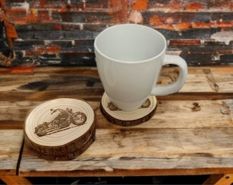 May include: Two wooden coasters with a laser-engraved image of a motorcycle. The coasters are stacked on top of each other. A white ceramic mug is sitting on top of one of the coasters.