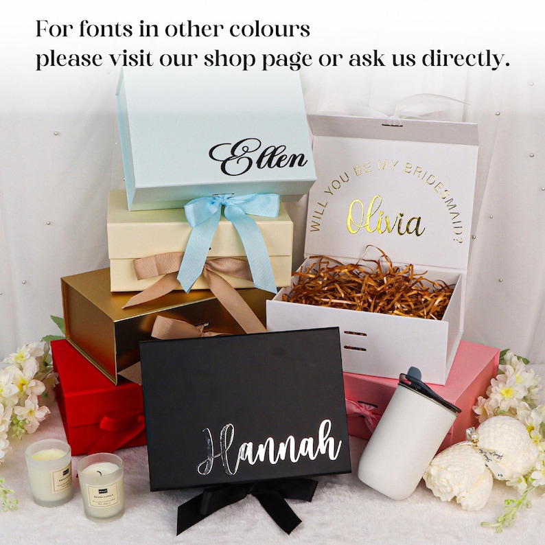 May include: A collection of gift boxes in various colors, including light blue, gold, black, and red, with decorative ribbons. Some boxes are personalized with names like "Ellen," "Olivia," and "Hannah." The text "For fonts in other colours please visit our shop page or ask us directly" is also visible.