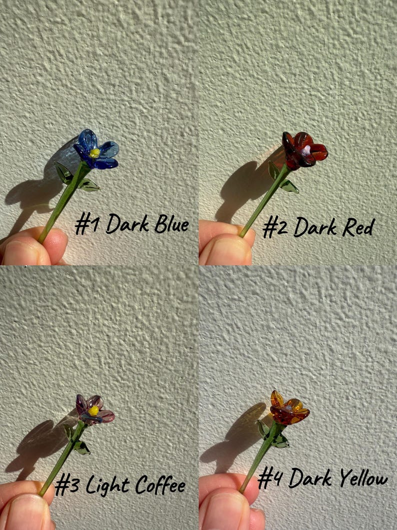 K&ouml;nnte beinhalten: Vier Glasblumen-Stiel-Ornamente in verschiedenen Farben: Dunkelblau, Dunkelrot, Hellbraun und Dunkelgelb. Jeder Stiel hat eine kleine Glasblume mit einem gr&uuml;nen Stiel und Bl&auml;ttern.