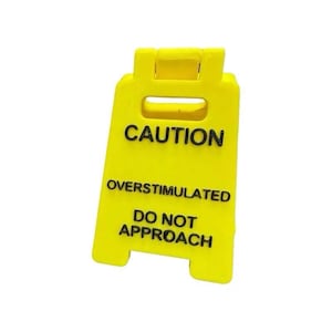Señal de escritorio de precaución sobreestimulado
