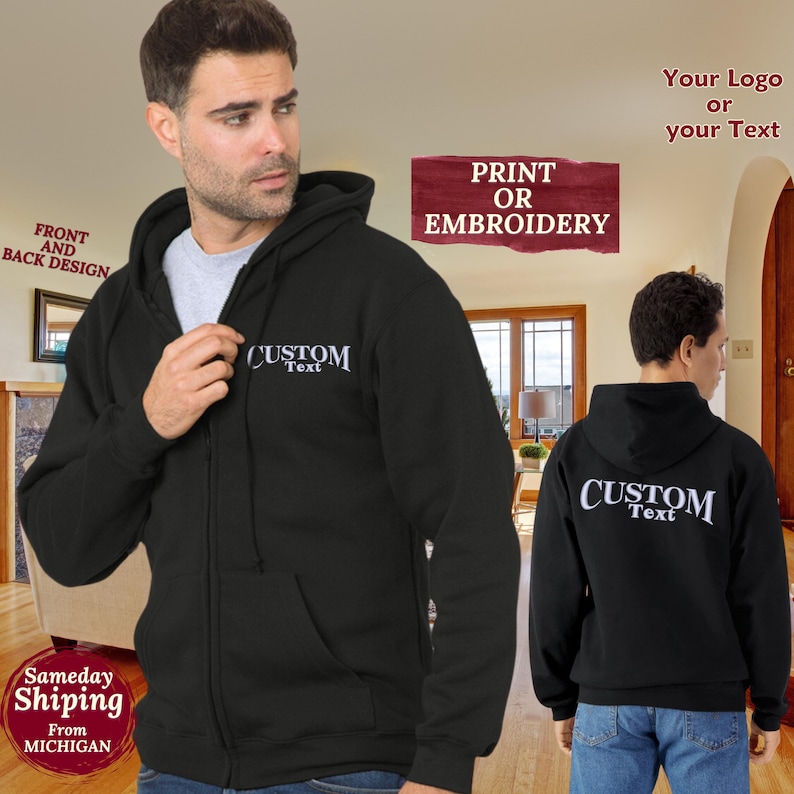 May include: Black zippered hoodie with a hood. The hoodie has a white embroidered design on the front that says "CUSTOM Text". The back of the hoodie has a white embroidered design that says "CUSTOM Text".