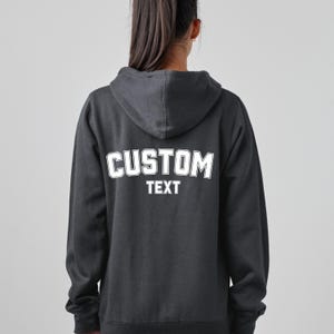 May include: A black hooded sweatshirt with a white "CUSTOM TEXT" graphic on the back.