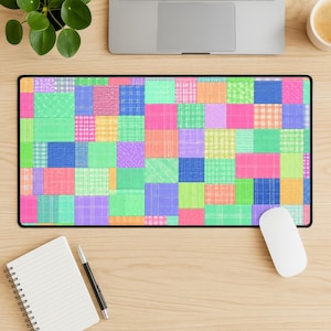Könnte beinhalten: Eine rechteckige Schreibtischunterlage mit einem lebendigen Patchwork-Design, das aus zahlreichen Quadraten und Rechtecken in verschiedenen Farben wie Pink, Grün, Blau, Orange, Lila und Gelb besteht, mit diversen Gitter-, Karo- und Punktmustern.