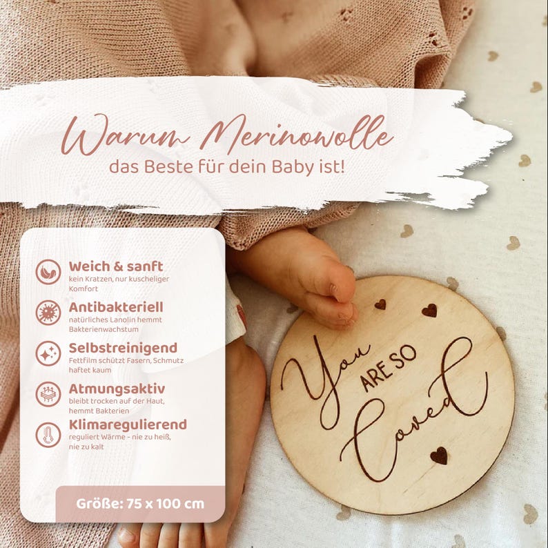 May include: A light pink knitted blanket with a pointelle pattern, a round wooden plaque engraved with the text You Are So Loved, and an informational card listing benefits of merino wool in German, measuring 75 by 100 cm in total size.