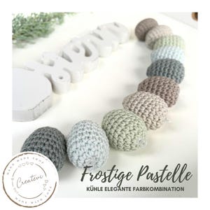 Könnte beinhalten: Eine Kette aus gehäkelten Pastell-Eiern mit dem Text "Frostige Pastelle" und "Kühle Elegante Farbkombination".