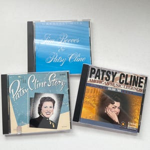 Op de afbeelding: Drie cd's met countrymuziekartiesten. Eén cd heet "Greatest Hits" van Jim Reeves & Patsy Cline. Een andere is "The Patsy Cline Story". De derde is "Patsy Cline American Music Legends Volume Two."