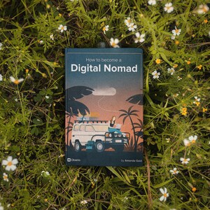 May include: A book titled "How to become a Digital Nomad" with an illustration of a person working on a laptop in a car. The book cover is blue with a sunset scene and palm trees.