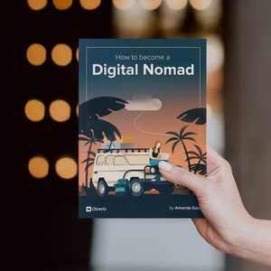 May include: A book cover with a blue background and the title "How to become a Digital Nomad" in white text. The cover features an illustration of a person working on a laptop in a van with palm trees and a sunset in the background.