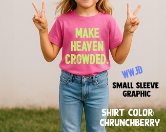 May include: A young person wearing a pink t-shirt with the words "MAKE HEAVEN CROWDED" in green. The person is also wearing blue jeans and sunglasses, and is giving the peace sign. The shirt color is "Chrunchberry".