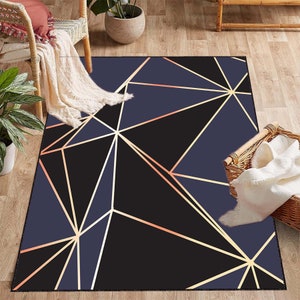 May include: A geometric area rug with a black background and gold lines forming a pattern of triangles. The rug has a subtle blue hue.
