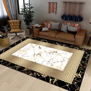 May include: A black and gold area rug with a white marble pattern in the center. The rug has a geometric border with a Greek key design.