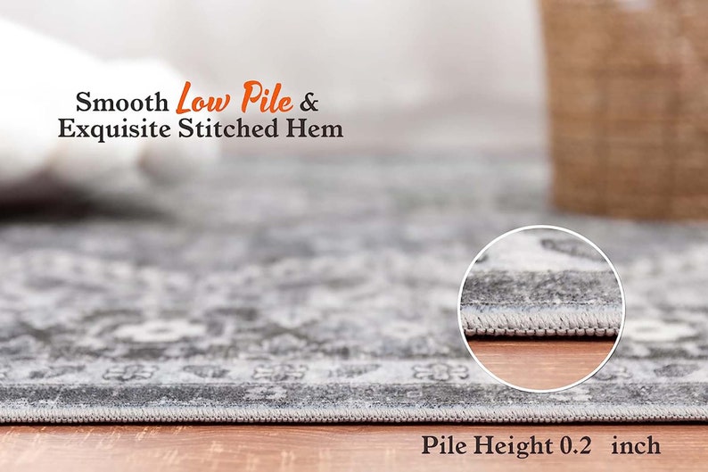 May include: Close-up of a gray area rug with a detailed pattern. The rug has a low pile and a stitched hem. The text "Smooth Low Pile & Exquisite Stitched Hem" is visible above the rug. The text "Pile Height 0.2 inch" is visible below the rug.