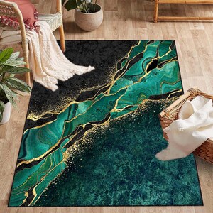 Puede incluir: Alfombra de &aacute;rea abstracta con un dise&ntilde;o de m&aacute;rmol verde y dorado. La alfombra tiene un fondo negro con vetas doradas y remolinos verdes.