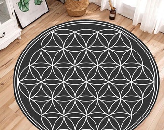 Op de afbeelding: Een rond tapijt in zwart en wit met een geometrisch levensbloemmotief.
