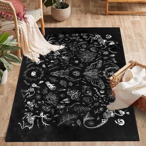Puede incluir: Alfombra negra y blanca con un diseño caprichoso que presenta varias ilustraciones de insectos, flores, huesos y otros elementos inspirados en la naturaleza. La alfombra tiene un fondo oscuro y contornos blancos.