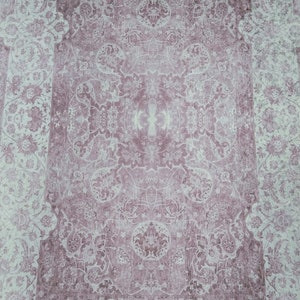 May include: A vintage-style rug with a floral pattern in shades of pink and white. The rug has a faded, distressed look, giving it a unique and antique feel.