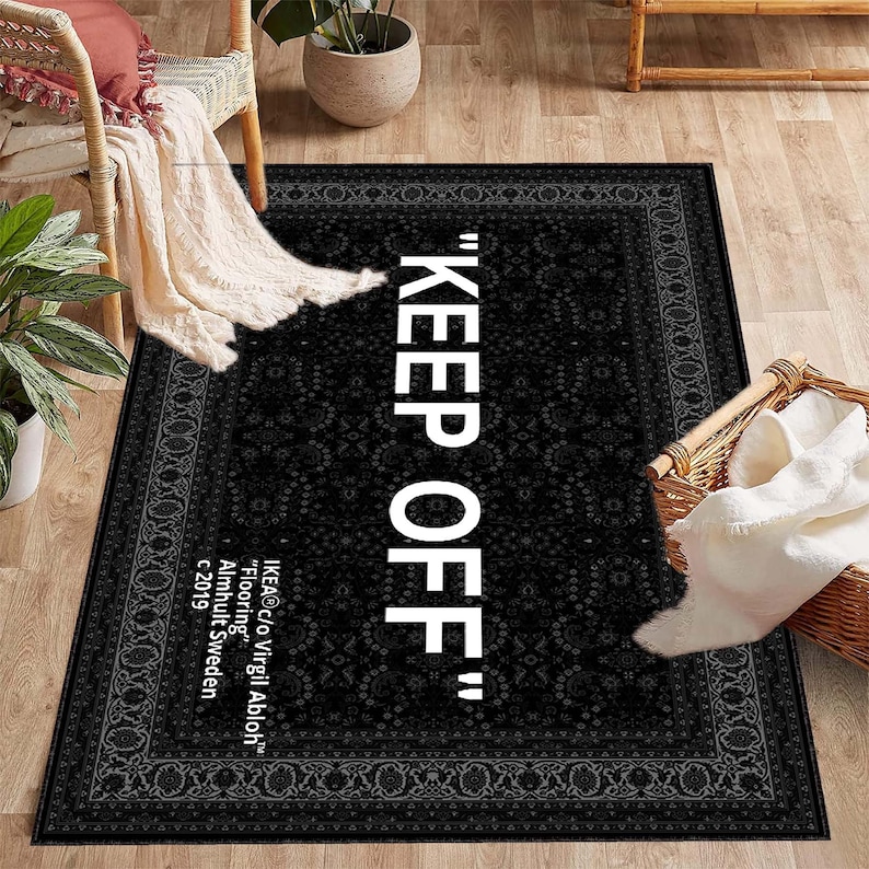 K&ouml;nnte beinhalten: Schwarz-wei&szlig;er Teppich mit traditionellem Muster an der Kante. Der Teppich tr&auml;gt den Schriftzug "KEEP OFF" in wei&szlig;en Buchstaben.