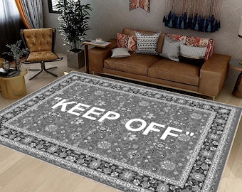 May include: A grey and white patterned rug with a white inscription that reads "KEEP OFF".