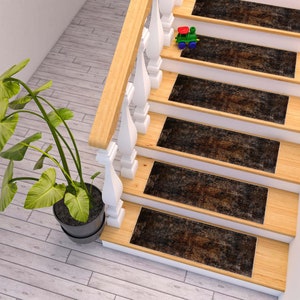 May include: A set of five brown and black patterned non-slip stair treads. The treads are placed on wooden stairs with a white railing.