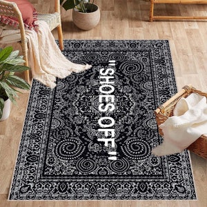 May include: Black and white patterned rug with the text "Shoes Off!" in white lettering.