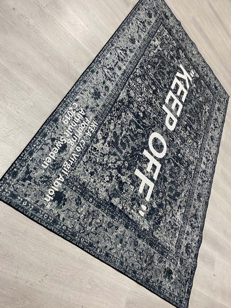 May include: Black and white rug with a distressed pattern and the text "KEEP OFF!" in white.