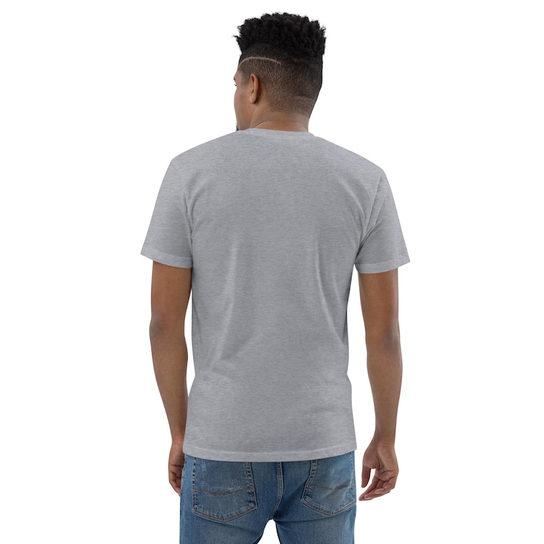 K&ouml;nnte beinhalten: Ein hellgraues Kurzarm-T-Shirt. Das Shirt besteht aus einem weichen Material und hat einen Rundhalsausschnitt. Das Model tr&auml;gt eine blaue Jeans. Der Hintergrund ist wei&szlig;.