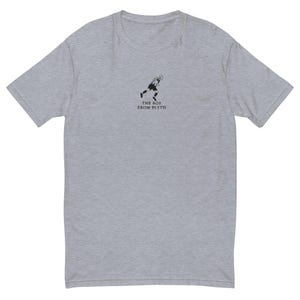 K&ouml;nnte beinhalten: Hellgraues T-Shirt mit einer kleinen schwarzen Grafik einer rennenden Person und dem Text "THE BOY FROM BLYTH" darunter. Das T-Shirt hat kurze &Auml;rmel und einen Rundhalsausschnitt.