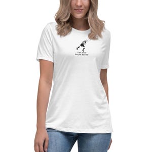 May include: White t-shirt with a black illustration of a tennis player and the words "THE BOY FROM BLYTH". The top has short sleeves and a loose fit, ideal for everyday wear.