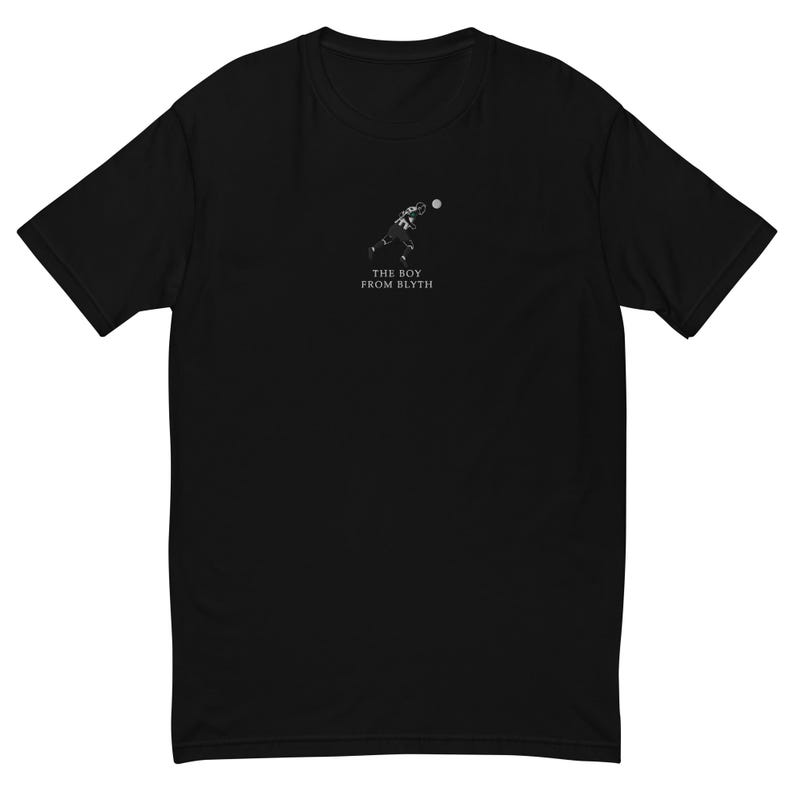 K&ouml;nnte beinhalten: Schwarzes T-Shirt mit einer kleinen wei&szlig;en Grafik eines Footballspielers, der einen Ball wirft. Unter der Grafik steht in Wei&szlig; der Text "THE BOY FROM BLYTH". Das Shirt hat kurze &Auml;rmel und einen Rundhalsausschnitt.