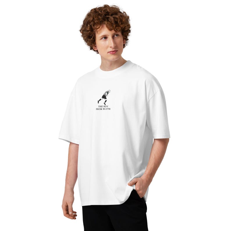May include: White oversized t-shirt with a small black graphic and text that reads "THE BOY FROM BLYTH". The shirt has short sleeves and a relaxed fit, suitable for casual wear.