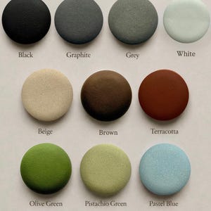 May include: A color palette chart titled TEXTURE colour palette featuring fifteen circular swatches with textured surfaces. The colors include black, graphite, grey, white, beige, brown, terracotta, olive green, pistachio green, pastel blue, pastel lavender, pastel lilac, and pastel pink.