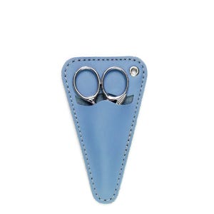 May include: A light blue triangular leather sheath containing a pair of small silver metal embroidery scissors. The sheath features white stitching along the edges and a single silver metal eyelet at the top right corner for hanging purposes.