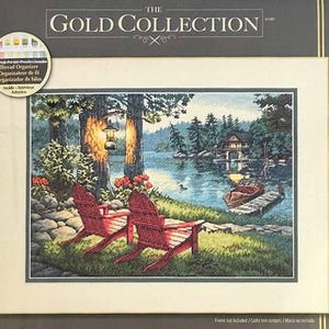 May include: A Dimensions Gold Collection counted cross stitch kit titled "Twilight's Calm." The kit features a scenic image of a lake with two red Adirondack chairs. The package dimensions are 16 x 11 inches.