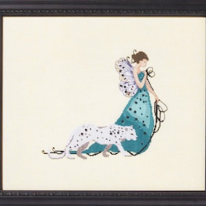 May include: Cross-stitch artwork in a black frame. The image depicts a woman in a teal dress with black polka dots, butterfly wings, and a snow leopard. The woman holds a leash attached to the snow leopard.