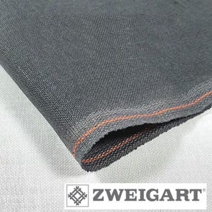 May include: Close-up of a black fabric with an orange thread running along the edge. The fabric is woven and has a textured surface. The fabric is labeled "ZWEIGART".