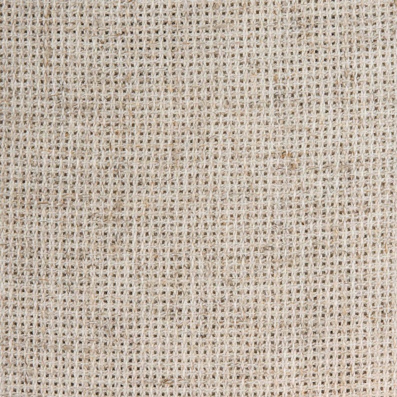 K&ouml;nnte beinhalten: Nahaufnahme eines beigefarbenen Gewebes mit einer feinen, gleichm&auml;&szlig;igen Webart. Der Stoff hat eine leicht raue Textur und ein nat&uuml;rliches, rustikales Aussehen.