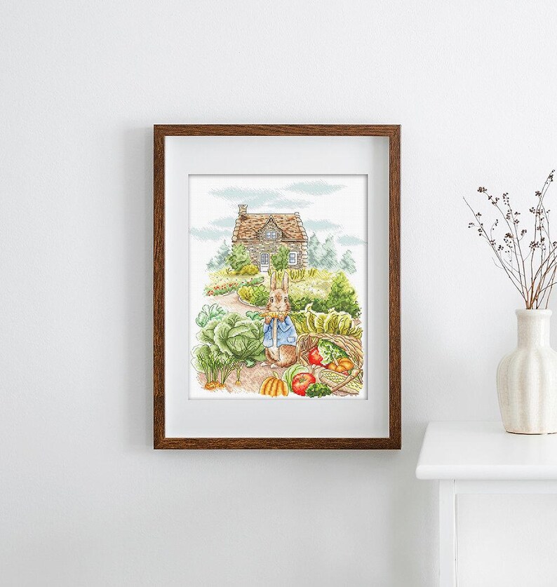 May include: A watercolor illustration of a rabbit holding a rake in front of a small stone cottage with a garden. The rabbit is wearing a blue shirt and has a basket of vegetables next to it.