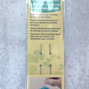 May include: Clover snag repair needles in a clear plastic package. The package has text in multiple languages, including English, French, and Spanish. The needles are designed to repair snags in knitted and woven garments.