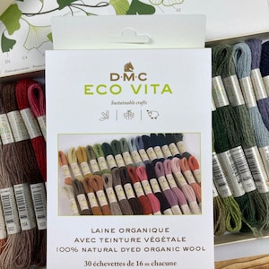 May include: A DMC Eco Vita embroidery thread set containing 30 skeins of 100% natural dyed organic wool. Each skein measures 17.5 yards. The packaging features the brand name, sustainable craft icons, and a color-coded image of the included thread.