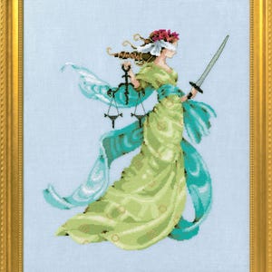 Può includere: Opera a punto croce di Lady Justice, incorniciata in oro. Indossa una benda, tiene in mano una bilancia e una spada, ed è drappeggiata in tessuto verde e turchese. Lo sfondo è azzurro.