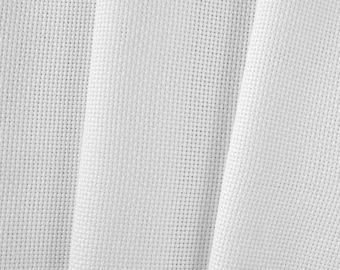 May include: Close-up of white cross-stitch fabric. The fabric is tightly woven with a grid-like pattern, ideal for embroidery projects. The fabric is folded, creating soft shadows and texture.