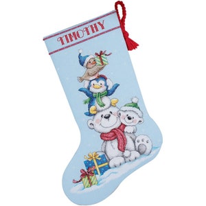 Op de afbeelding: Een blauwe kerstsok met de naam "Timothy" geborduurd aan de bovenkant. De sok heeft een witte ijsbeer met een rode sjaal, een pinguïn met een blauwe sjaal en een klein vogeltje dat een cadeaudoos vasthoudt.