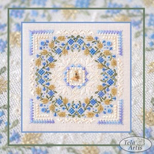 May include: A square cross-stitch embroidery with a floral design in blue, gold, and green on a cream background. The design features a central motif and a border. The embroidery is framed with a light blue border.