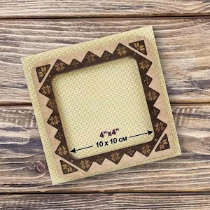 May include: A wooden embroidery hoop with a 4" x 4" (10 cm x 10 cm)  canvas. The hoop has a decorative design around the edge.